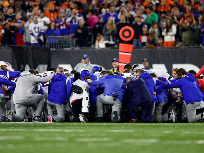 布法罗比尔队的球员和工作人员跪后，达玛哈姆林倒塌在NFL足球比赛对阵辛辛那提孟加拉虎1月6日. 2, 2023 in Cincinnati. (Kevin Sabitus/Getty Images)